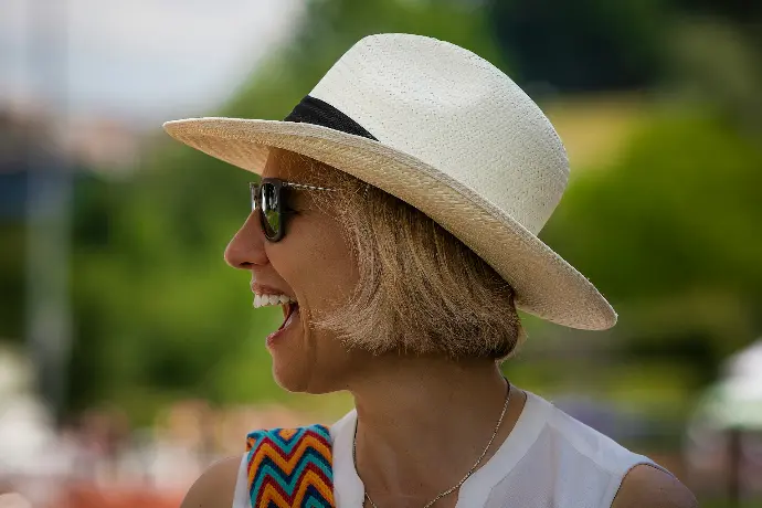 a woman wearing a white hat and sunglasses